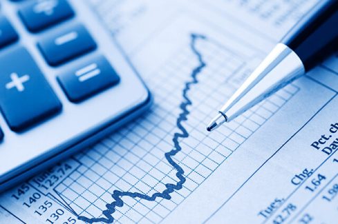 Close-up of a Calculator and Pen on a Financial Newspaper.  Blue-toned.