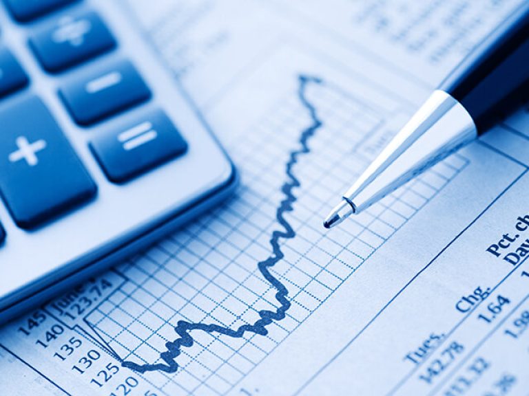 Close-up of a Calculator and Pen on a Financial Newspaper.  Blue-toned.